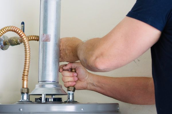 HVAC technician repairing a water heater